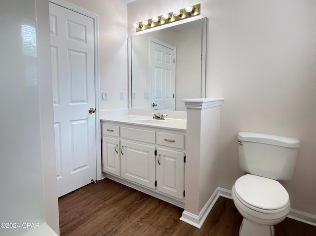 bathroom with vanity, toilet, and hardwood / wood-style floors