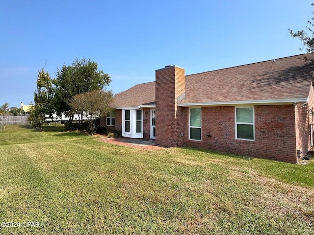 rear view of property with a yard and a patio area