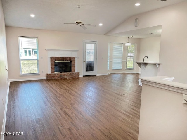 unfurnished living room with lofted ceiling, dark hardwood / wood-style flooring, and a healthy amount of sunlight