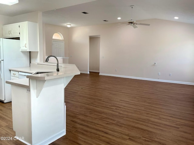 kitchen featuring white cabinetry, lofted ceiling, sink, kitchen peninsula, and dark wood-type flooring