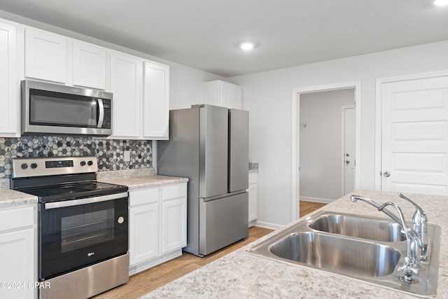 kitchen featuring light hardwood / wood-style floors, white cabinets, stainless steel appliances, and sink