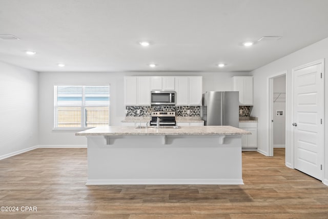 kitchen featuring a center island with sink, appliances with stainless steel finishes, and white cabinetry