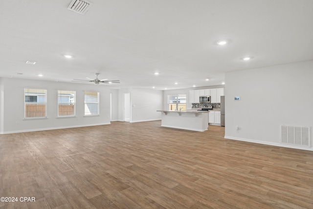 unfurnished living room with light hardwood / wood-style floors and ceiling fan