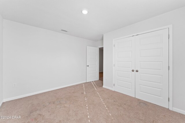 unfurnished bedroom with a closet and carpet flooring