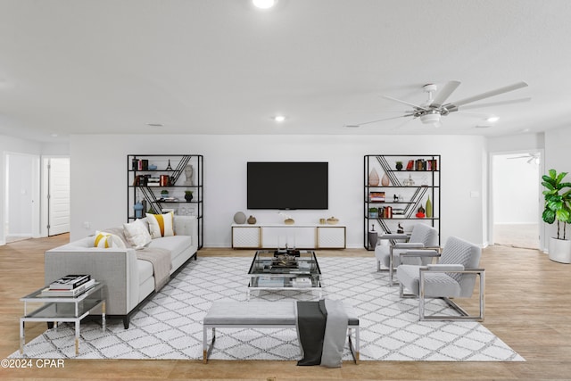 living room featuring light hardwood / wood-style flooring and ceiling fan