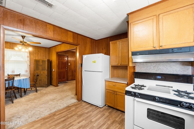 kitchen featuring wooden walls, light wood-type flooring, white appliances, and ceiling fan