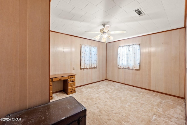 interior space with wood walls and ceiling fan