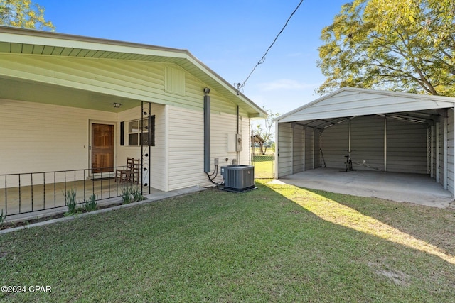 view of side of property with cooling unit, a yard, and a carport