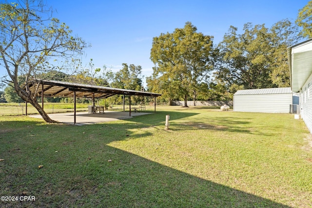 view of yard with a carport and a storage unit