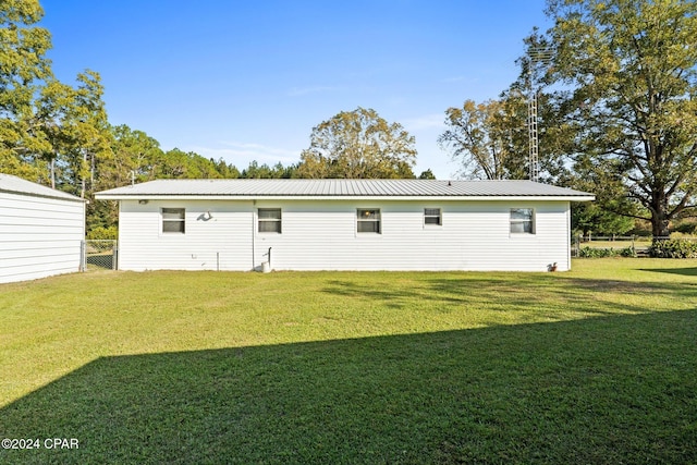 rear view of property featuring a yard