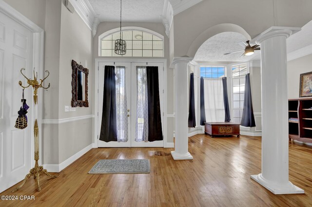 entrance foyer featuring ornamental molding, hardwood / wood-style floors, a textured ceiling, and ceiling fan with notable chandelier