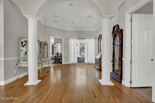 foyer with ornamental molding, hardwood / wood-style floors, and decorative columns