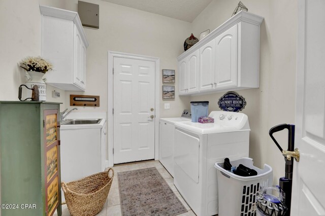 laundry area featuring independent washer and dryer, cabinets, sink, and light tile patterned floors