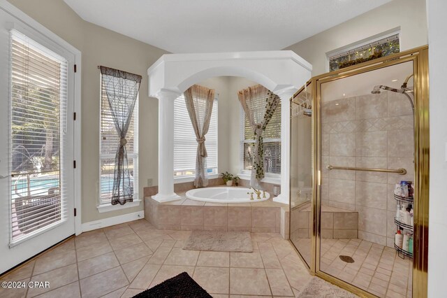 bathroom featuring ornate columns, a wealth of natural light, tile patterned flooring, and plus walk in shower