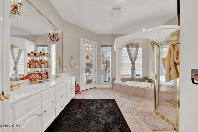 bathroom with a textured ceiling, independent shower and bath, ornate columns, tile patterned floors, and vanity