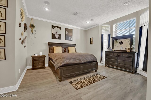 bedroom featuring crown molding, a textured ceiling, and light wood-type flooring