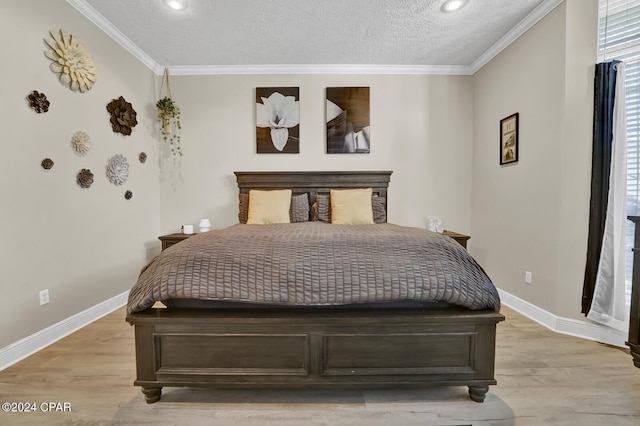 bedroom with light hardwood / wood-style floors, ornamental molding, and a textured ceiling