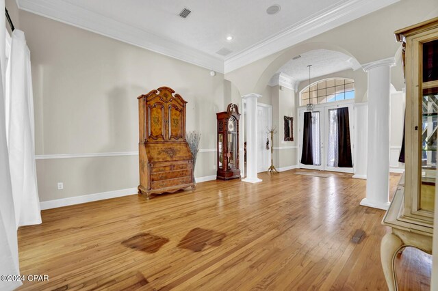 foyer featuring crown molding, light hardwood / wood-style floors, and decorative columns