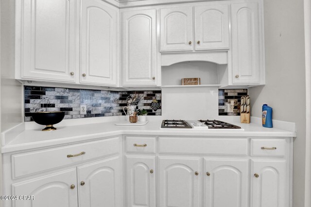 kitchen with stainless steel gas cooktop, tasteful backsplash, and white cabinets