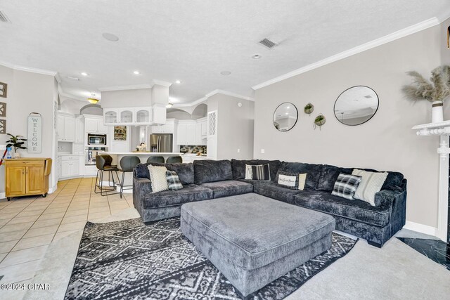 tiled living room featuring crown molding and a textured ceiling