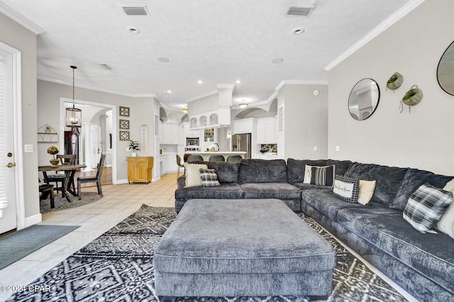 living room with ornamental molding, light tile patterned flooring, and a textured ceiling