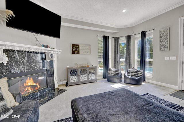 living room featuring ornamental molding, a textured ceiling, carpet, and a high end fireplace