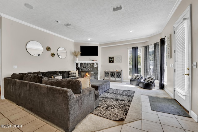 living room with a premium fireplace, crown molding, light tile patterned flooring, and a textured ceiling