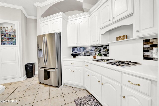 kitchen featuring decorative backsplash, appliances with stainless steel finishes, white cabinets, and light tile patterned floors