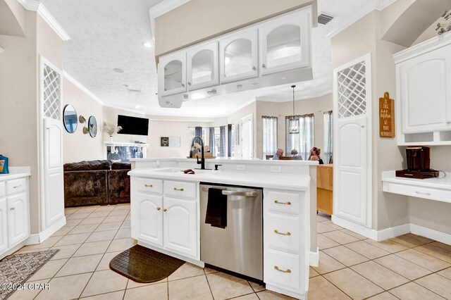 kitchen with crown molding, white cabinets, stainless steel dishwasher, and light tile patterned floors