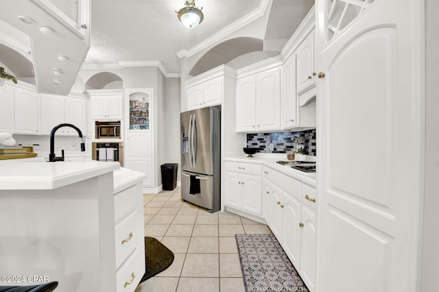 kitchen with tasteful backsplash, stainless steel appliances, white cabinets, crown molding, and light tile patterned floors