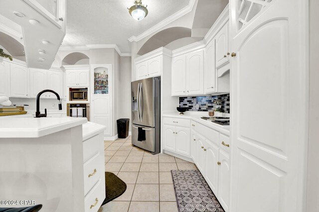 kitchen featuring white cabinetry, stainless steel appliances, light tile patterned floors, and ornamental molding