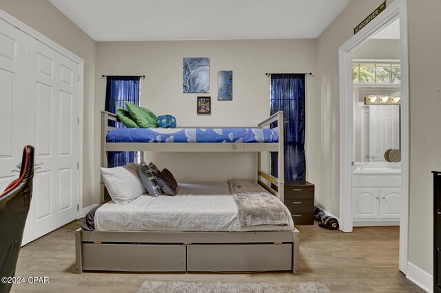 bedroom with light hardwood / wood-style flooring and ensuite bath