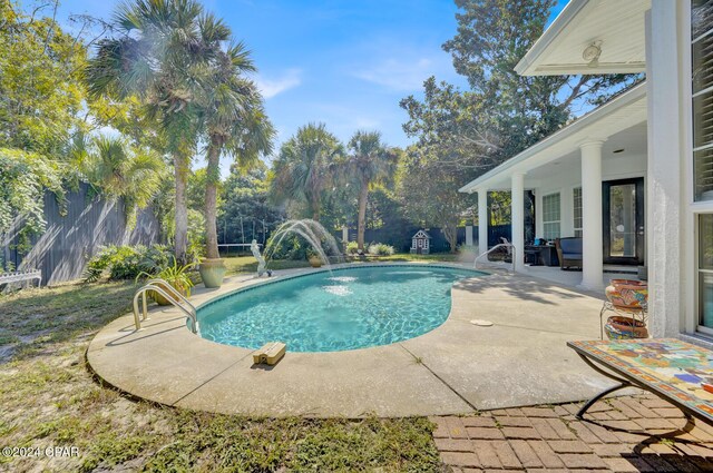 view of pool featuring pool water feature and a patio