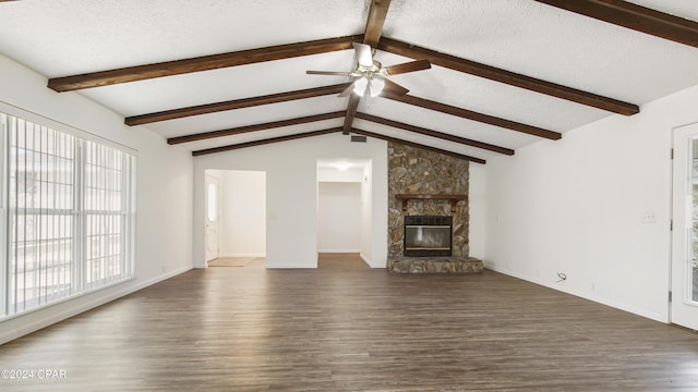 unfurnished living room with dark wood-style floors, a ceiling fan, vaulted ceiling with beams, a fireplace, and a textured ceiling