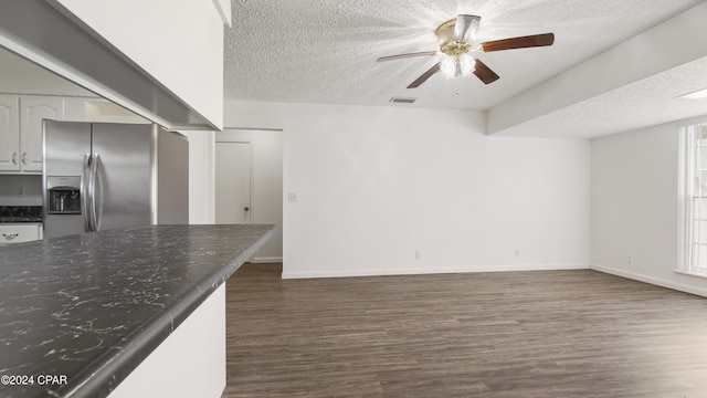 kitchen with dark wood-style floors, visible vents, ceiling fan, stainless steel refrigerator with ice dispenser, and a textured ceiling