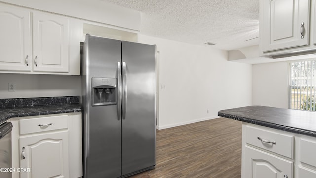 kitchen featuring dark countertops, visible vents, white cabinets, and stainless steel appliances