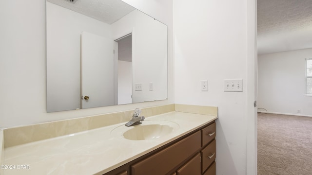 bathroom featuring a textured ceiling and vanity