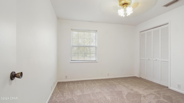 unfurnished bedroom featuring visible vents, baseboards, carpet, and a closet