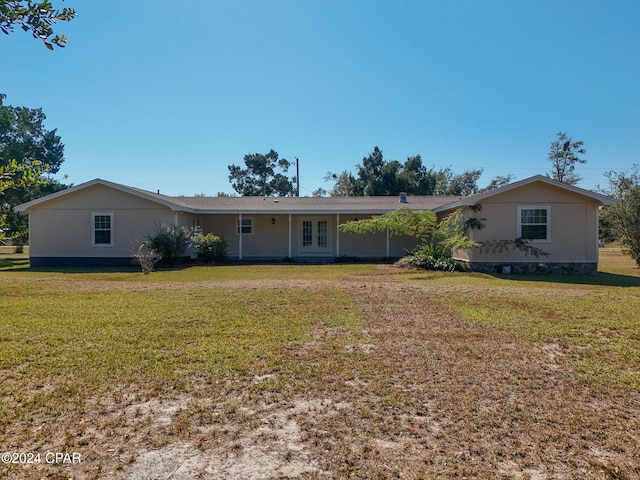 ranch-style home with a front lawn and french doors