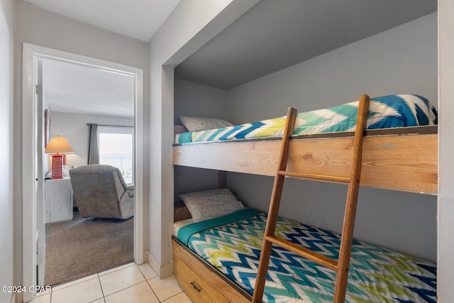 bedroom with light tile patterned floors and light colored carpet