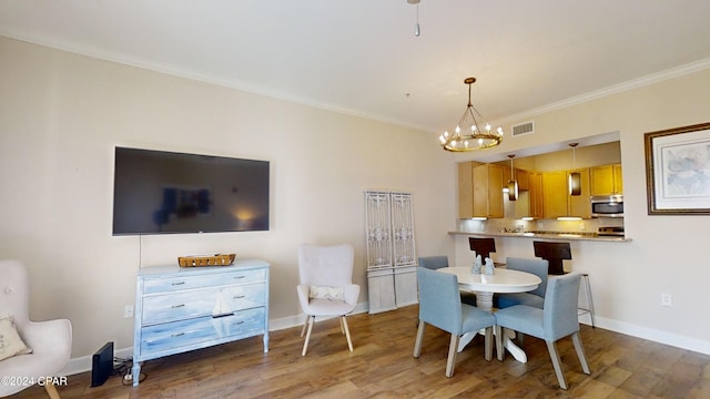 8700 Front Beach Rd Unit 5309, Panama City Beach, FL 32407 - dining area with wood finished floors, ornamental molding, baseboards, visible vents, and a notable chandelier