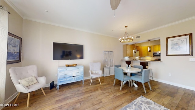 8700 Front Beach Rd Unit 5309, Panama City Beach, FL 32407 - dining space featuring ornamental molding, an inviting chandelier, visible vents, and wood finished floors