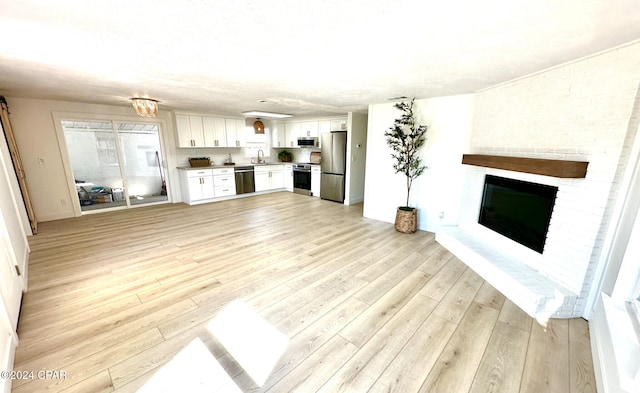 unfurnished living room featuring sink and light wood-type flooring