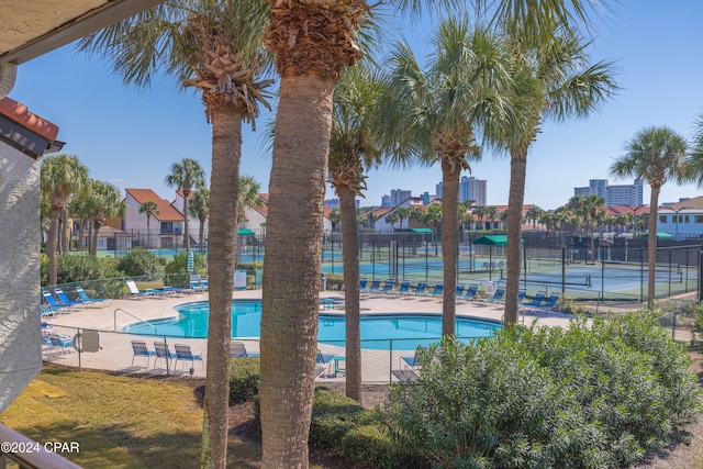 view of swimming pool featuring tennis court