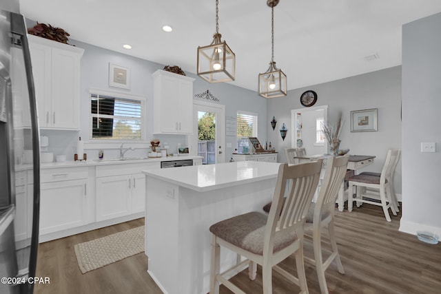 kitchen with sink, a center island, pendant lighting, white cabinetry, and dark hardwood / wood-style flooring