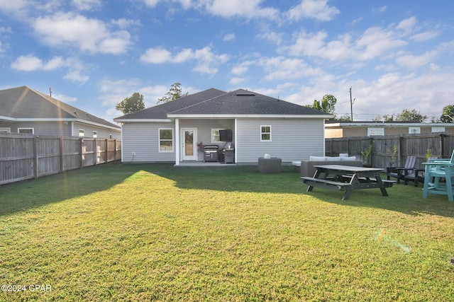 rear view of property featuring a yard and a patio area