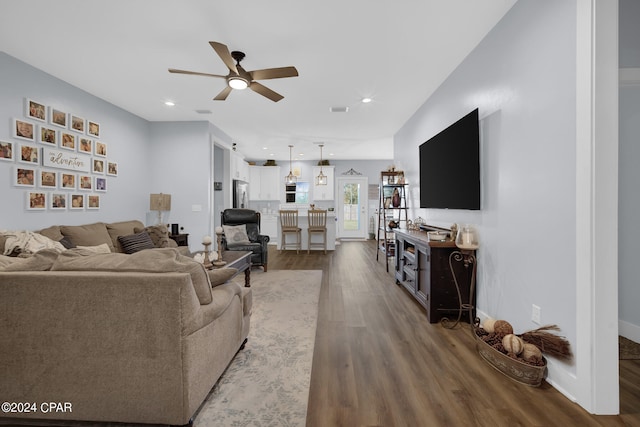 living room featuring ceiling fan and dark hardwood / wood-style flooring