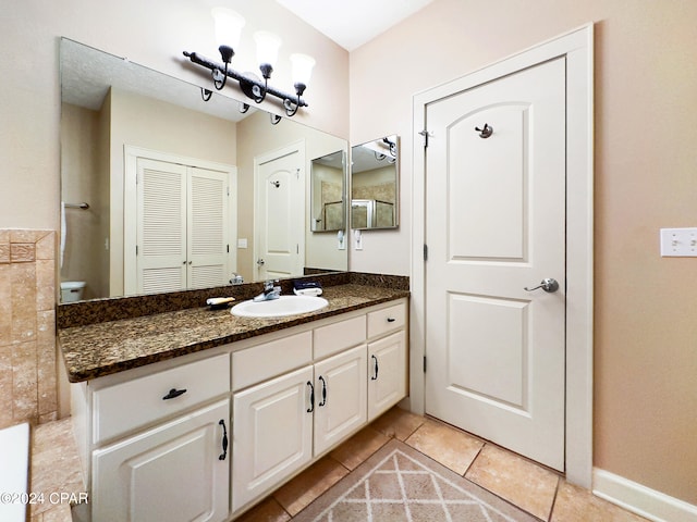 bathroom with vanity, toilet, and tile patterned floors