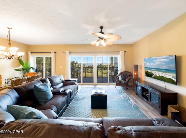 living room with light hardwood / wood-style floors and ceiling fan with notable chandelier