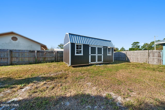 rear view of house featuring a yard and a storage shed